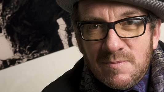 Elvis Costello & The Imposters: The Return Of The Spectacular Spinning Songbook - Backdrop
